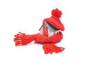 Small house model with a red scarf and hat.