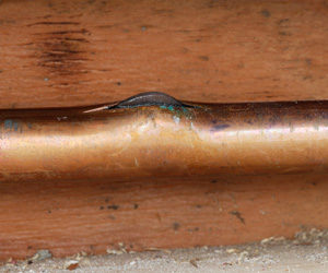 Closeup of frozen, cracked copper pipe.