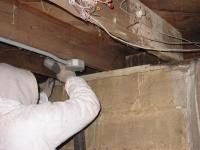 Worker installing basement ceiling insulation in Baltimore, MD.