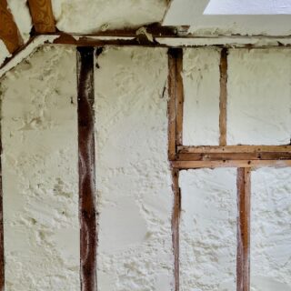 Close up of white spray foam insulation inside a home's wall