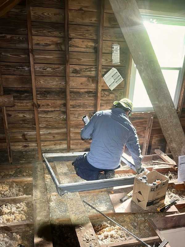 fiberglass installation technician working in attic