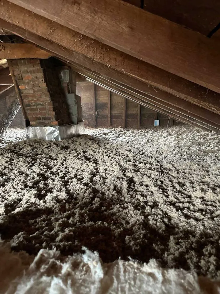 Cellulose blown insulation application in an attic by DeVere Insulation Home Performance, highlighting a thorough installation process that improves thermal performance and energy efficiency.
