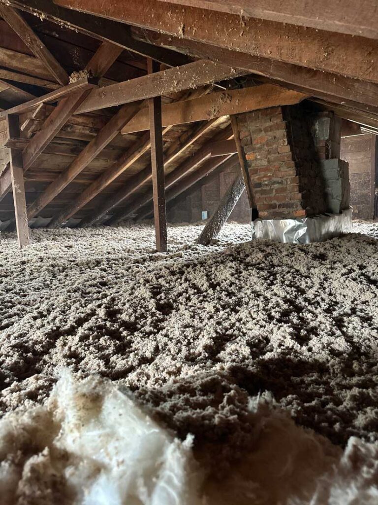 Cellulose blown insulation being installed in an attic by DeVere Insulation Home Performance, demonstrating an effective method for enhancing energy efficiency and reducing heat loss.