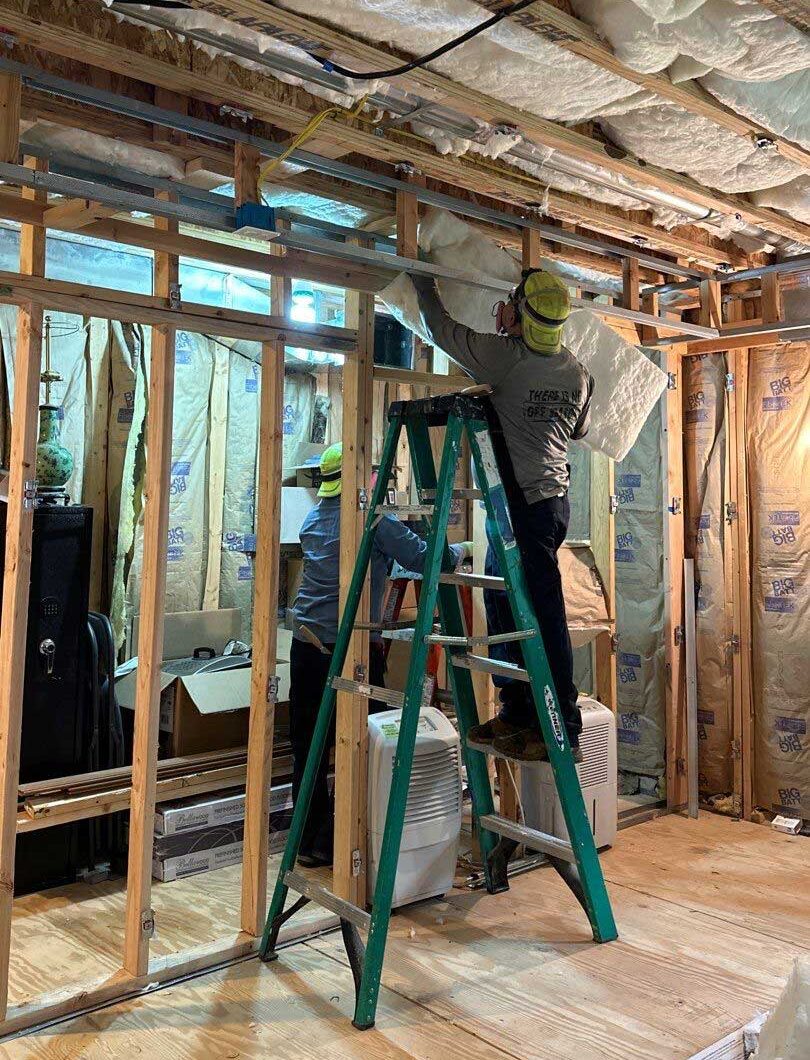 Batt insulation being installed by DeVere Insulation Home Performance, showcasing a careful application designed to improve energy efficiency and comfort in homes.