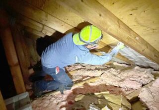 Insulation specialist insulating home's attic ventilation.