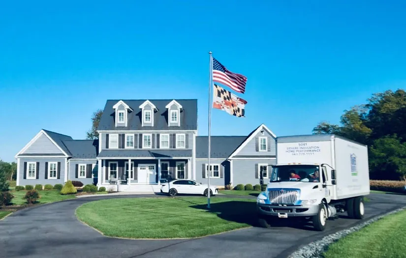 Image of DeVere Insulation Home Performance's fleet truck parked in front of a residential home, ready to perform a professional energy audit. The truck displays the company’s branding, emphasizing their dedication to enhancing home energy efficiency.