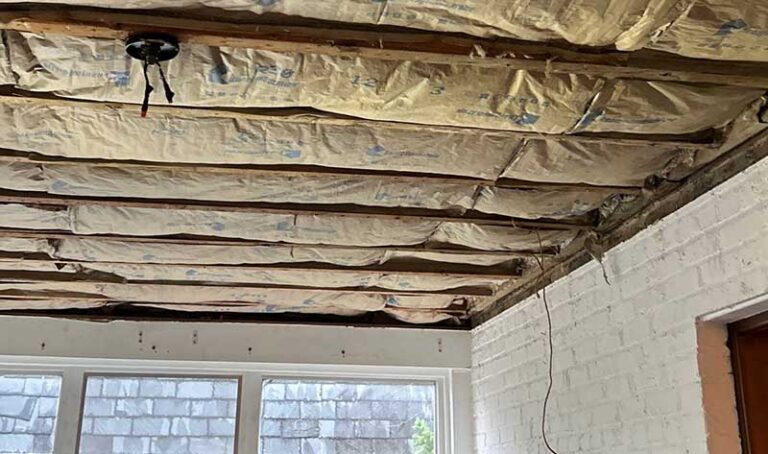 Close-up of high-quality batt insulation being installed in a residential attic. Enhance your home's thermal performance with expert insulation services from DeVere Insulation & Home Performance.