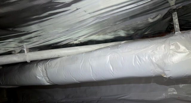 Spray foam insulation applied to crawl space foundation walls with a clean vapor barrier on the floor.