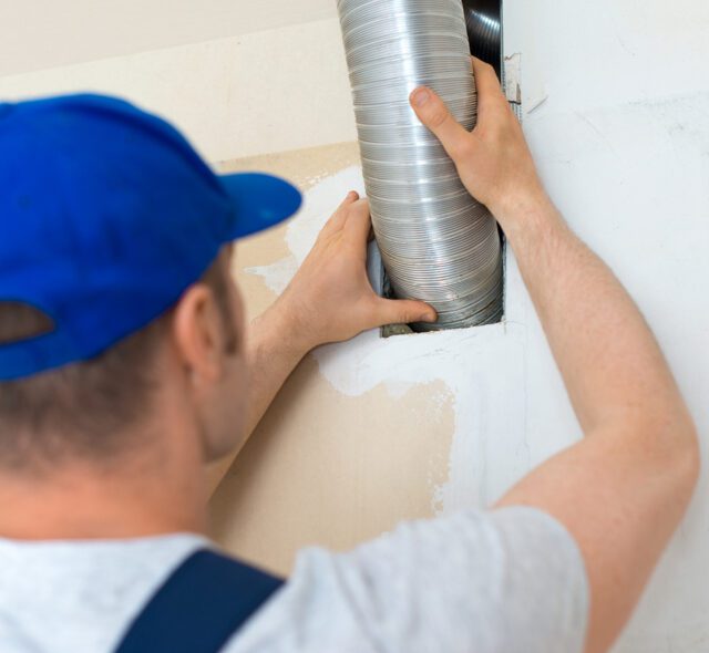 Man setting up the ventilation system indoors.